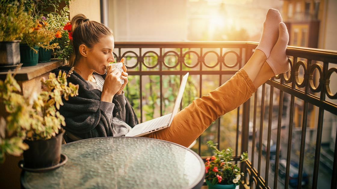 woman-balcony-sun-laptop-16-9-1120x630px