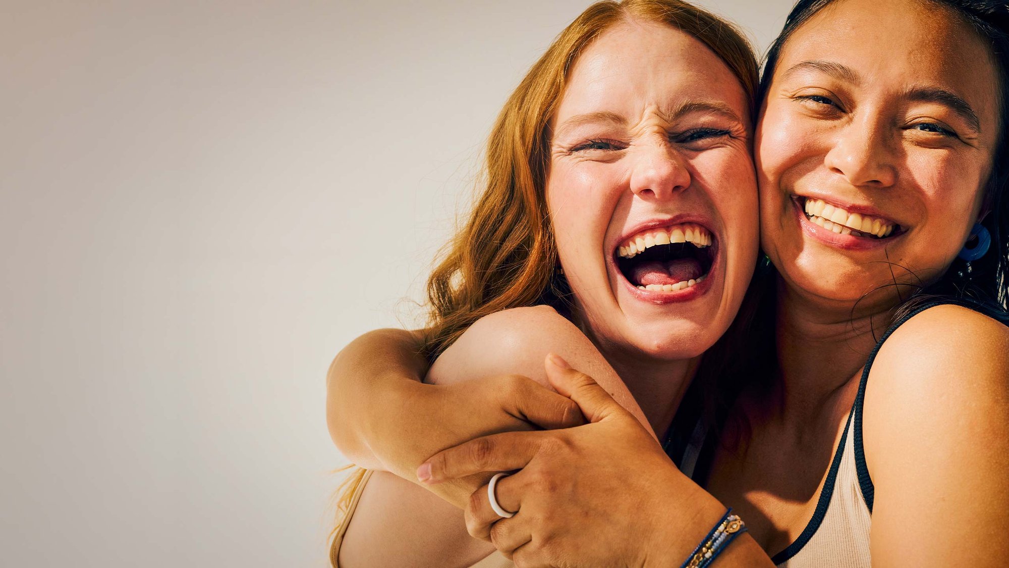 women-laughing-hugging-hero-16-9-2560x1440px