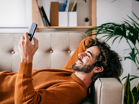 man-couch-phone-happy-4-3-544x408px