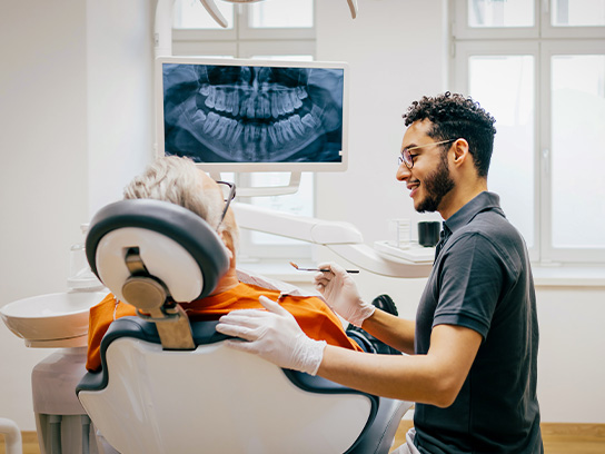 Hammaslääkäri kuvauttamassa asiakkaan hampaita.